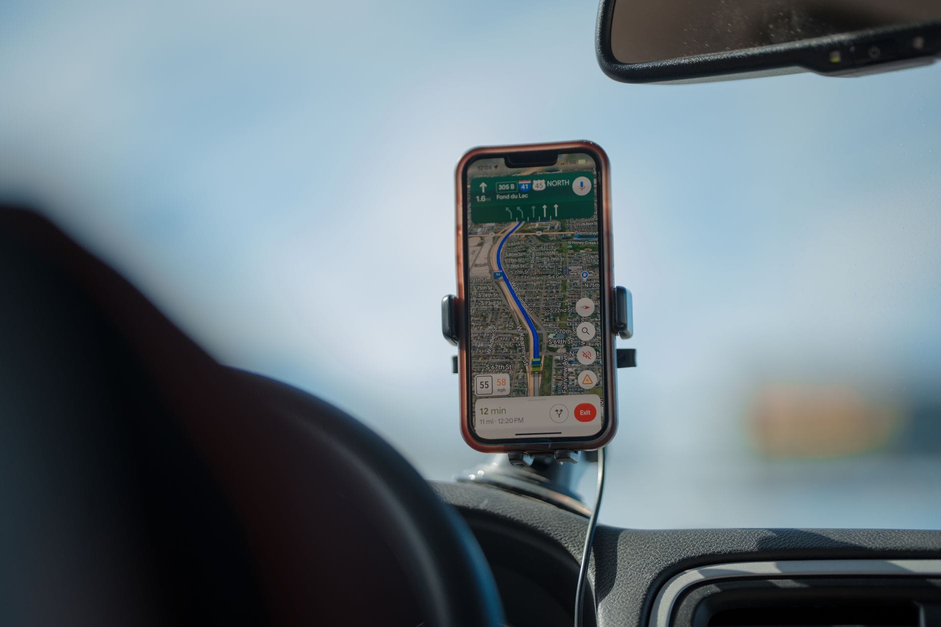 Smartfon z nawigacją GPS na desce rozdzielczej samochodu w trasie